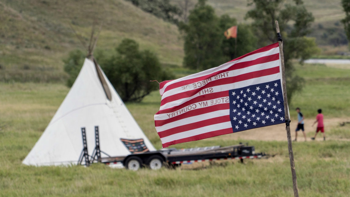 An American flag flies upside down in an officially recognized signal of distress at the Sacred Stone protest camp in Canon Ball, North Dakota. The camp was created to house protesters of the Dakota Access Pipeline. (Photo: Joe Brusky/flickr/cc)