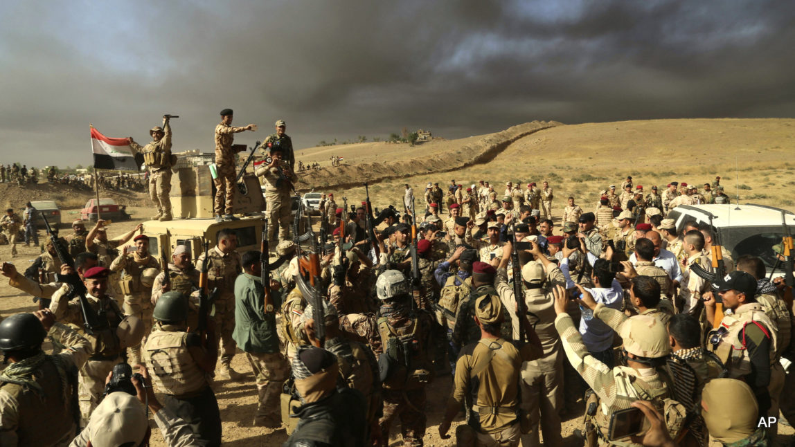 Iraqi army soldiers raise their weapons in celebration on the outskirts of Mosul, Iraq, Thursday, Oct. 20, 2016.