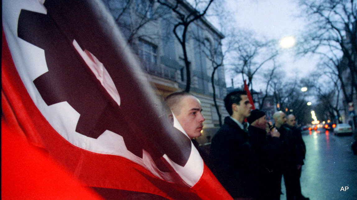 A handful of mostly skinhead members of the Hungarian Welfare Alliance, a Neo-Nazi group, hold their flags as they demonstrate in front of the Austrian embassy in Budapest, Hungary.