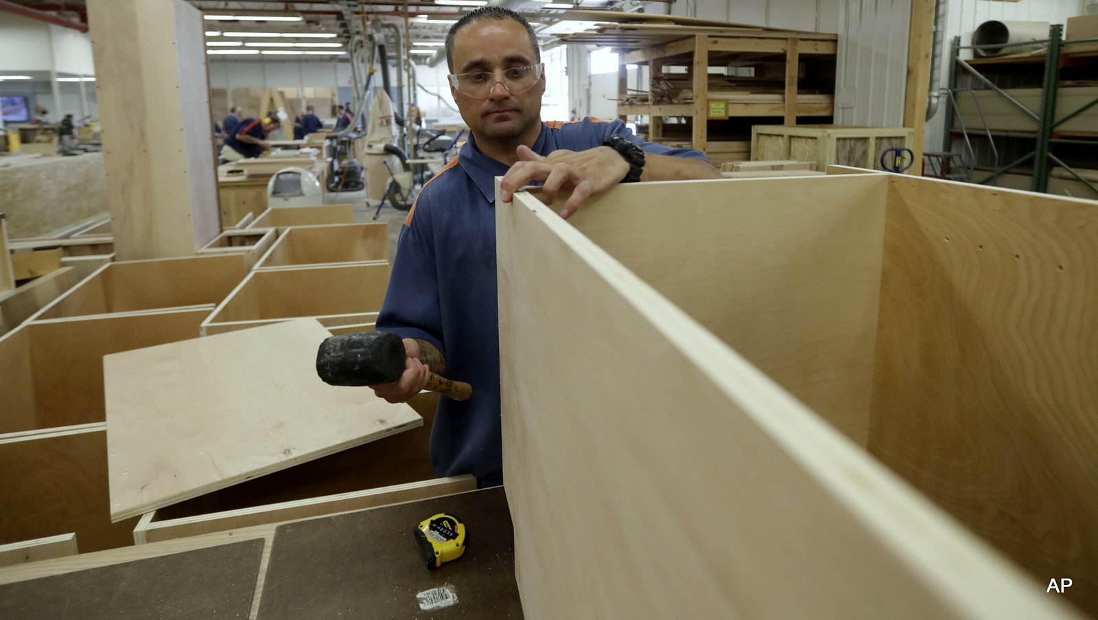 In a photo from Friday, July 8, 2016, inmate William Garrett works on a cabinet at the Habitat for Humanity Prison Build at the Ionia Correctional Facility in Ionia, Mich.
