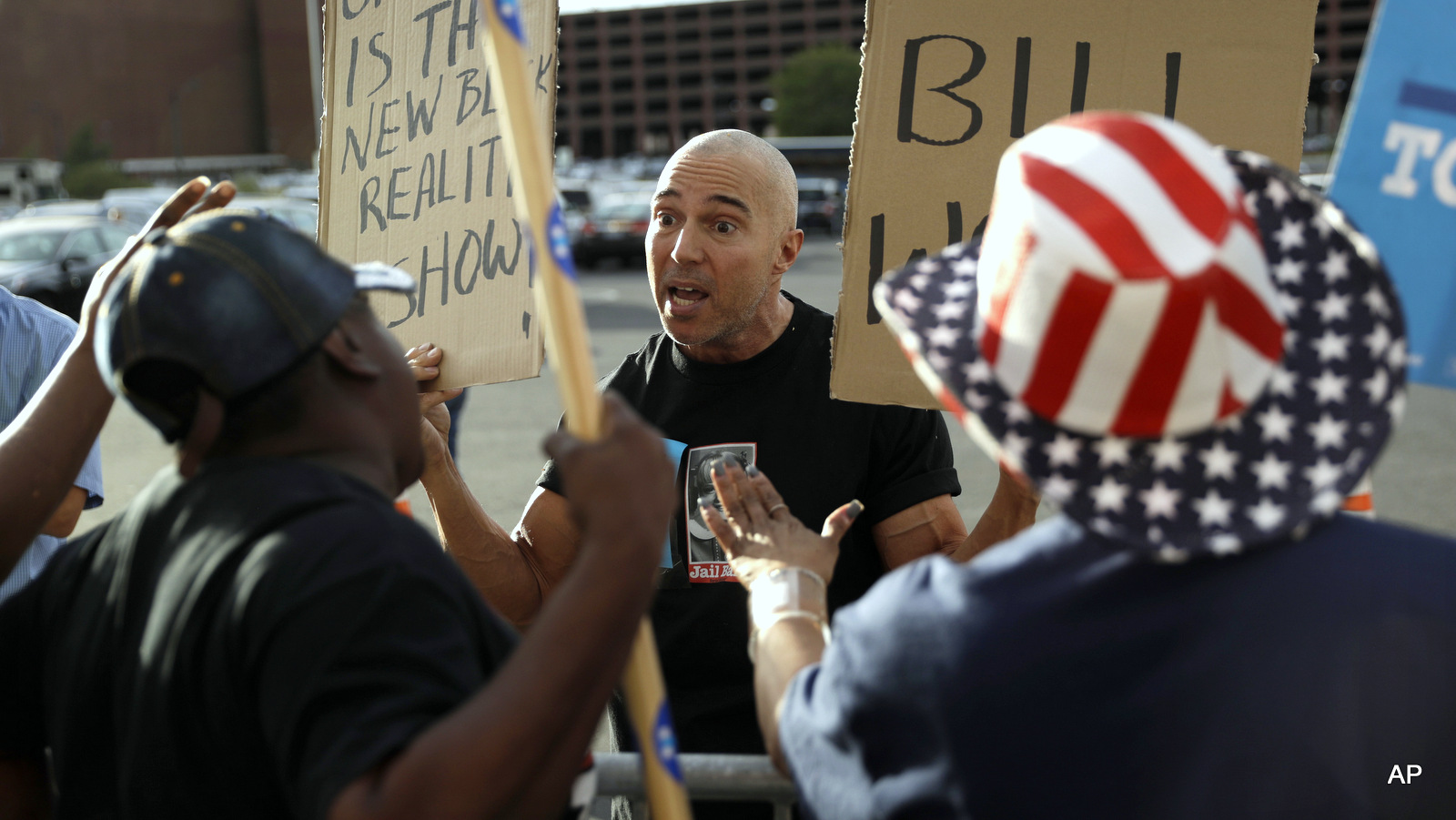 Mathew Burgart, center, a supporter of Republican presidential candidate Donald Trump, argues with supporters of Democratic presidential candidate Hillary Clinton before a rally with Clinton, Wednesday, Oct. 12, 2016, in Las Vegas.