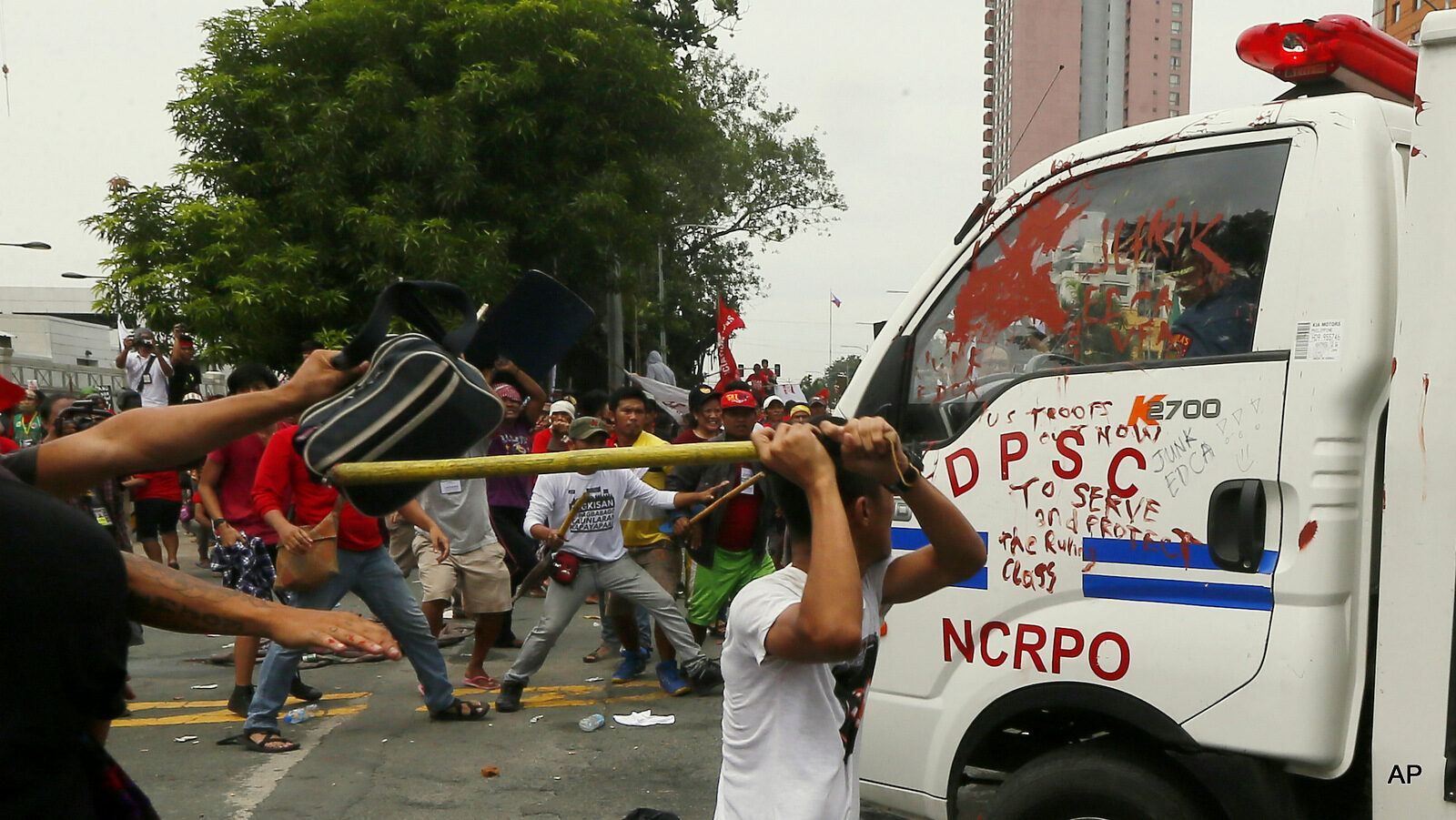 Protesters hit a Philippine National Police van after it rammed into protesters outside the U.S. Embassy in Manila Wednesday, Oct. 19, 2016. The police van rammed into protesters, leaving several bloodied, as an anti-U.S. rally turned violent Wednesday at the embassy. The protesters, consisting of students, workers and tribespeople, were demanding an end to the presence of visiting U.S. troops in the Philippines and to support a call by President Rodrigo Duterte for a foreign policy not dependent on the U.S., the country's longtime treaty ally.