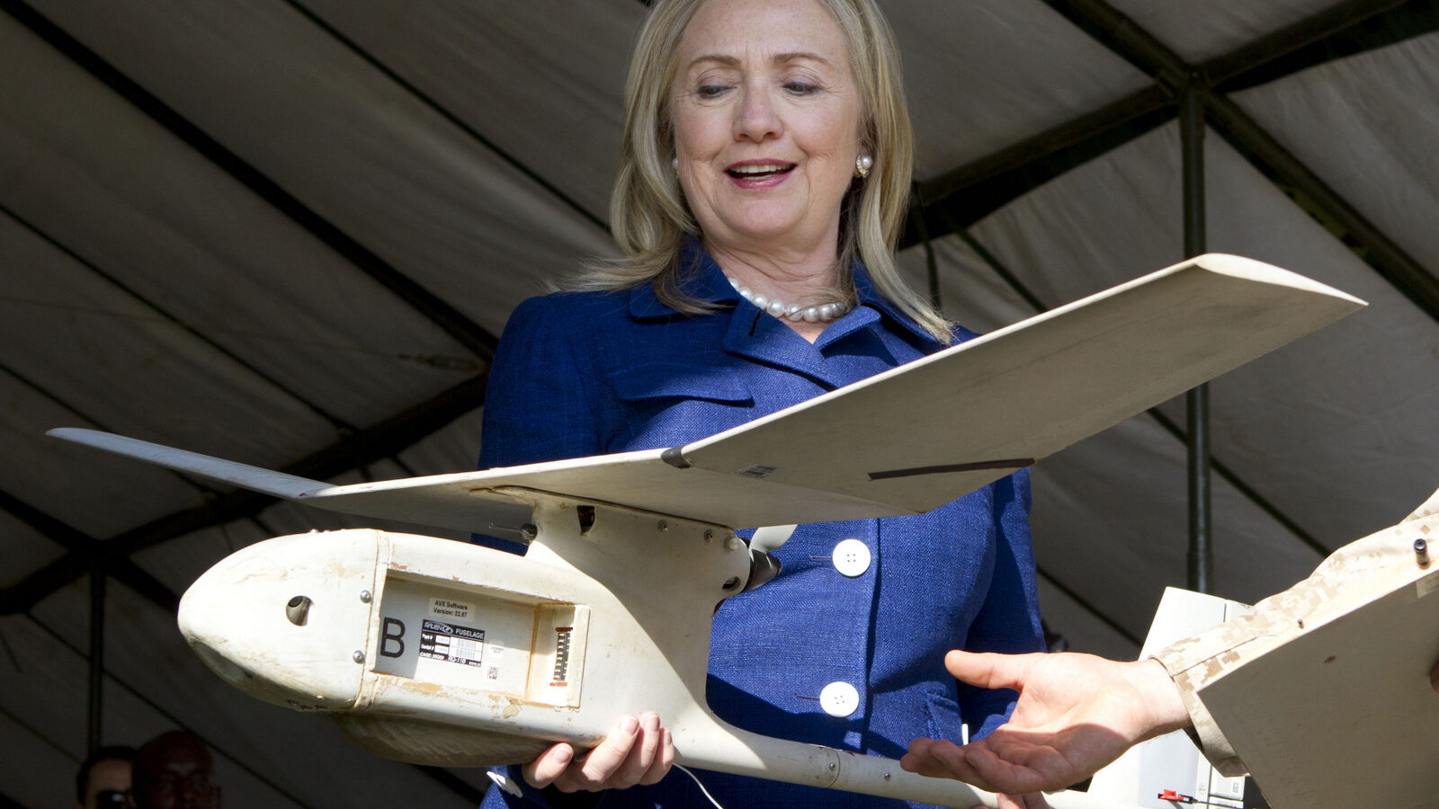 Secretary of State Hillary Rodham Clinton holds a small U.S.-made drone that the Ugandan military uses in Somalia to fight al-Qaida linked militants, Friday, Aug. 3, 2012, during a demonstration and briefing at Kasenyi Military Base in Kampala, Uganda.