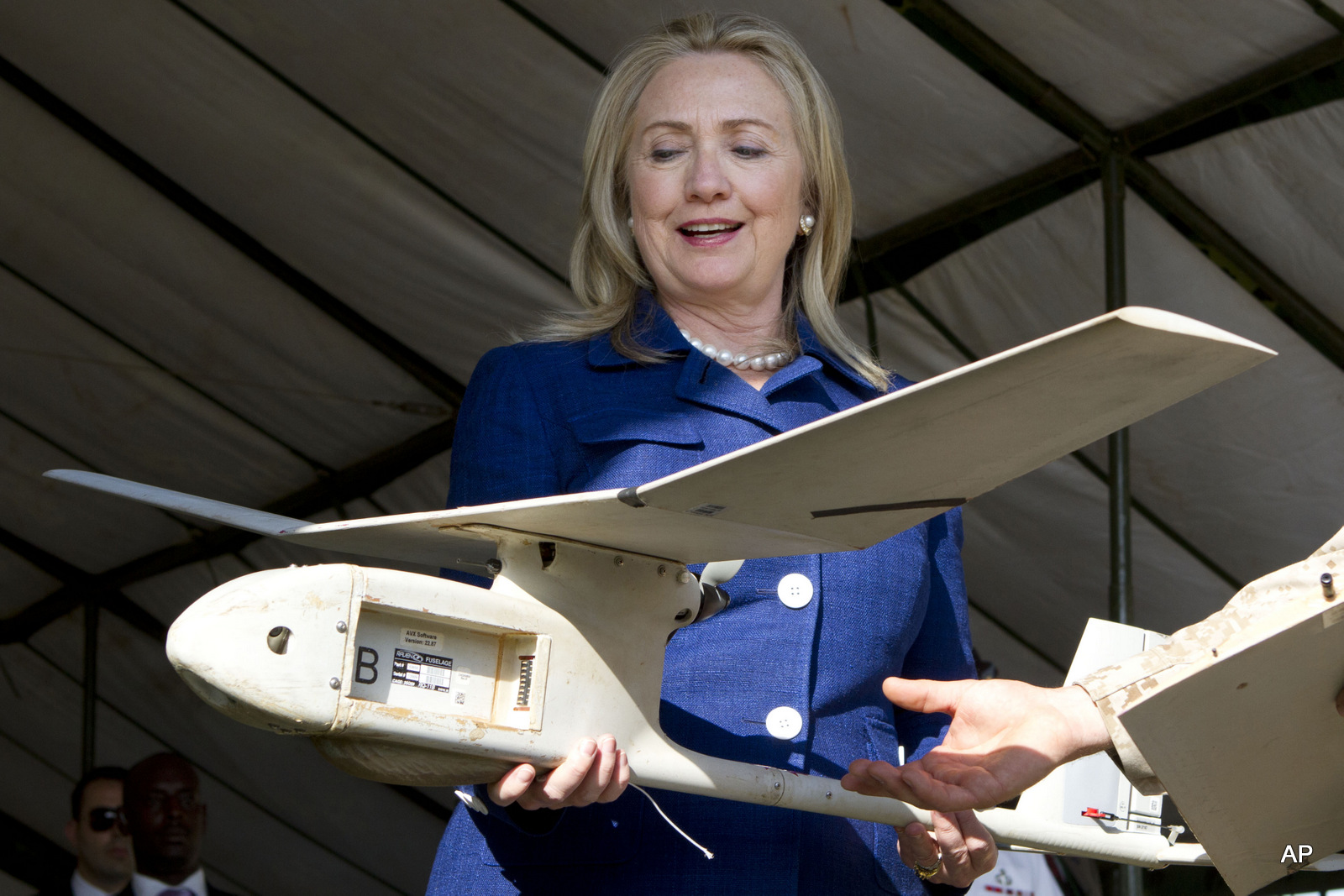 La secretaria de Estado Hillary Rodham Clinton tiene un pequeño avión no tripulado de fabricación estadounidense que los militares ugandeses utilizan en Somalia para combatir a los militantes vinculados a al-Qaida, el viernes 3 de agosto de 2012, durante una manifestación y reunión informativa en la Base Militar de Kasenyi en Kampala, Uganda.