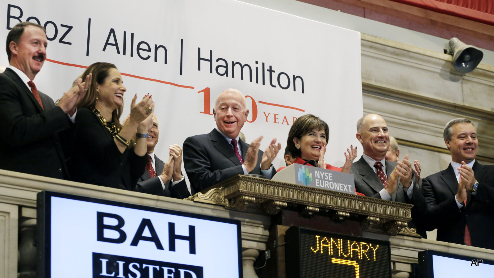 Booz Allen Hamilton Chairman and CEO Ralph Shrader, center, and guests attend the opening bell ceremony at the New York Stock Exchange.