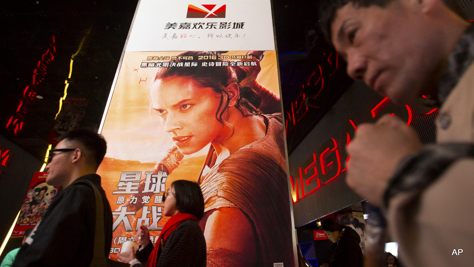 People walk past a poster for the new "Star Wars" movie at a movie theater in Beijing as the record-breaking film opened in China. 