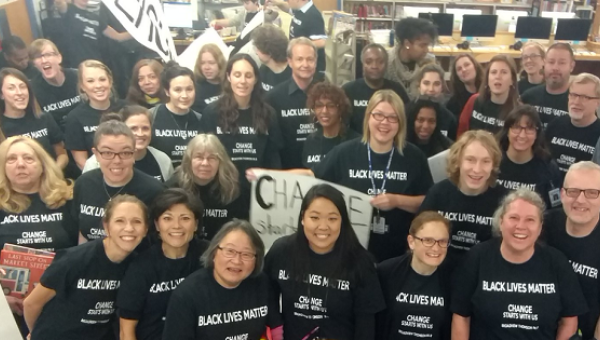 Teachers at a Seattle school pose for a photo as they sport Black Lives Matter shirts and banners. | Photo: Twitter / @seapubschools