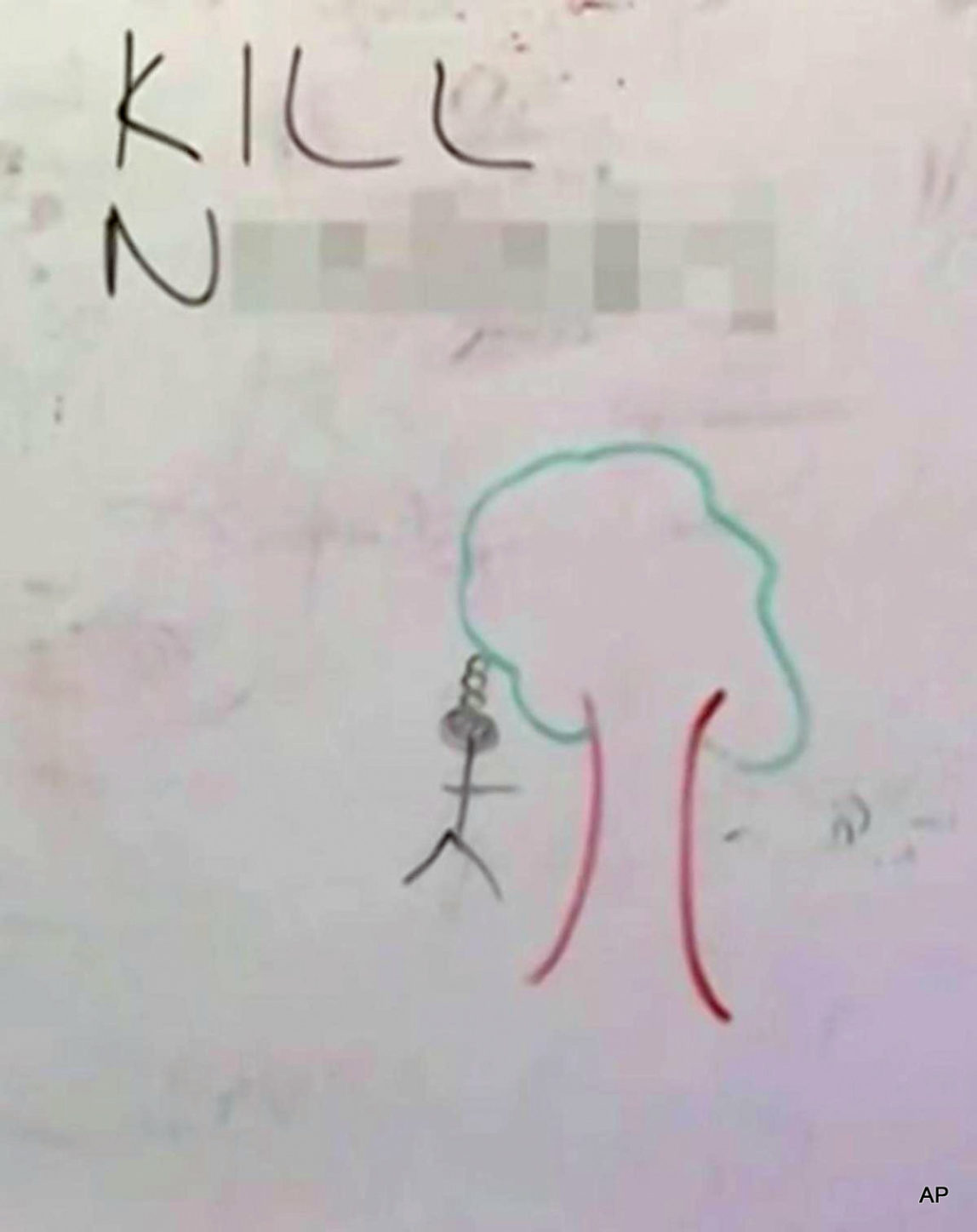 The message on the whiteboard read, “Kill N-----s,” along with a drawing of a stick figure hanging from a tree with a rope around its neck.