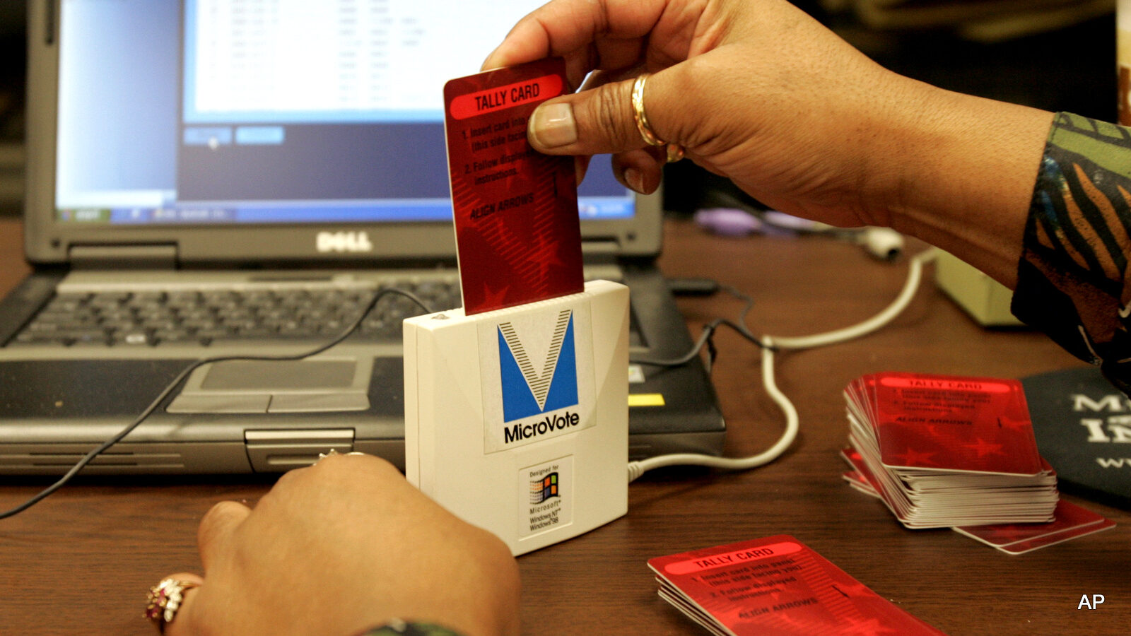 A vote counter inserts a tally card from an electronic voting machine into a card readers as they count votes at the Lake County Government Center in Crown Point, Ind., Nov. 4, 2008.