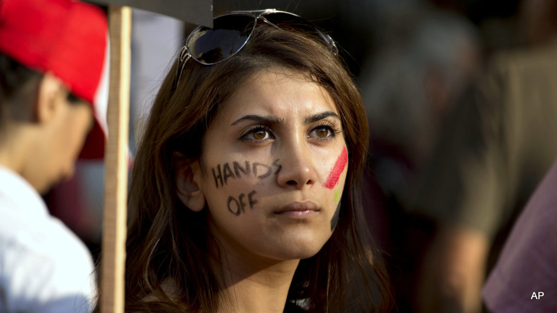 A Syrian woman with the words "hands off" painted on her face takes part in a protest against US military action in Syria across the road from the entrance of Downing Street in London, Aug. 28, 2013.