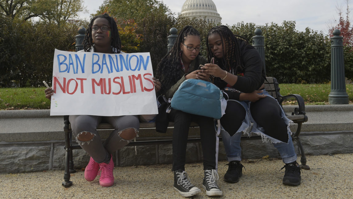 Washington area high school students sitting on a park bench, from left, Makeda Lydia, 14, Sarah Tewodros, 14 and Serwah Lydia, 17, protest on Capitol Hill in Washington, Tuesday, Nov. 15, 2016. (AP Photo/Susan Walsh)