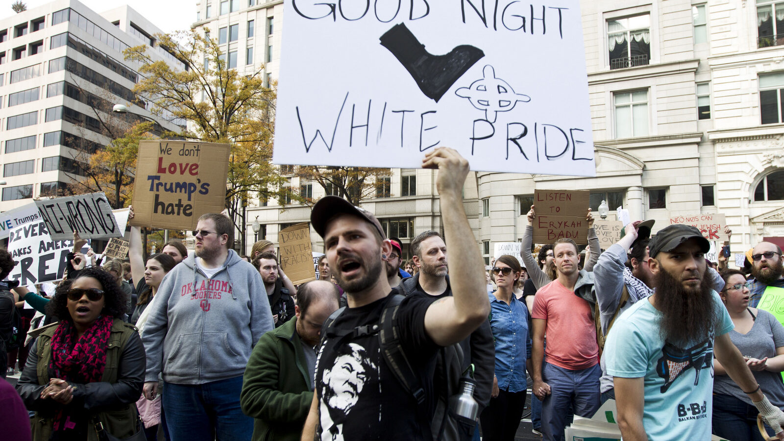 A demonstrator holds a banner as they protest in Pennsylvania Avenue outside of the Trump Hotel in Washington in opposition of President-elect Donald Trump, on Saturday, Nov. 19, 2016. ( AP Photo/Jose Luis Magana)