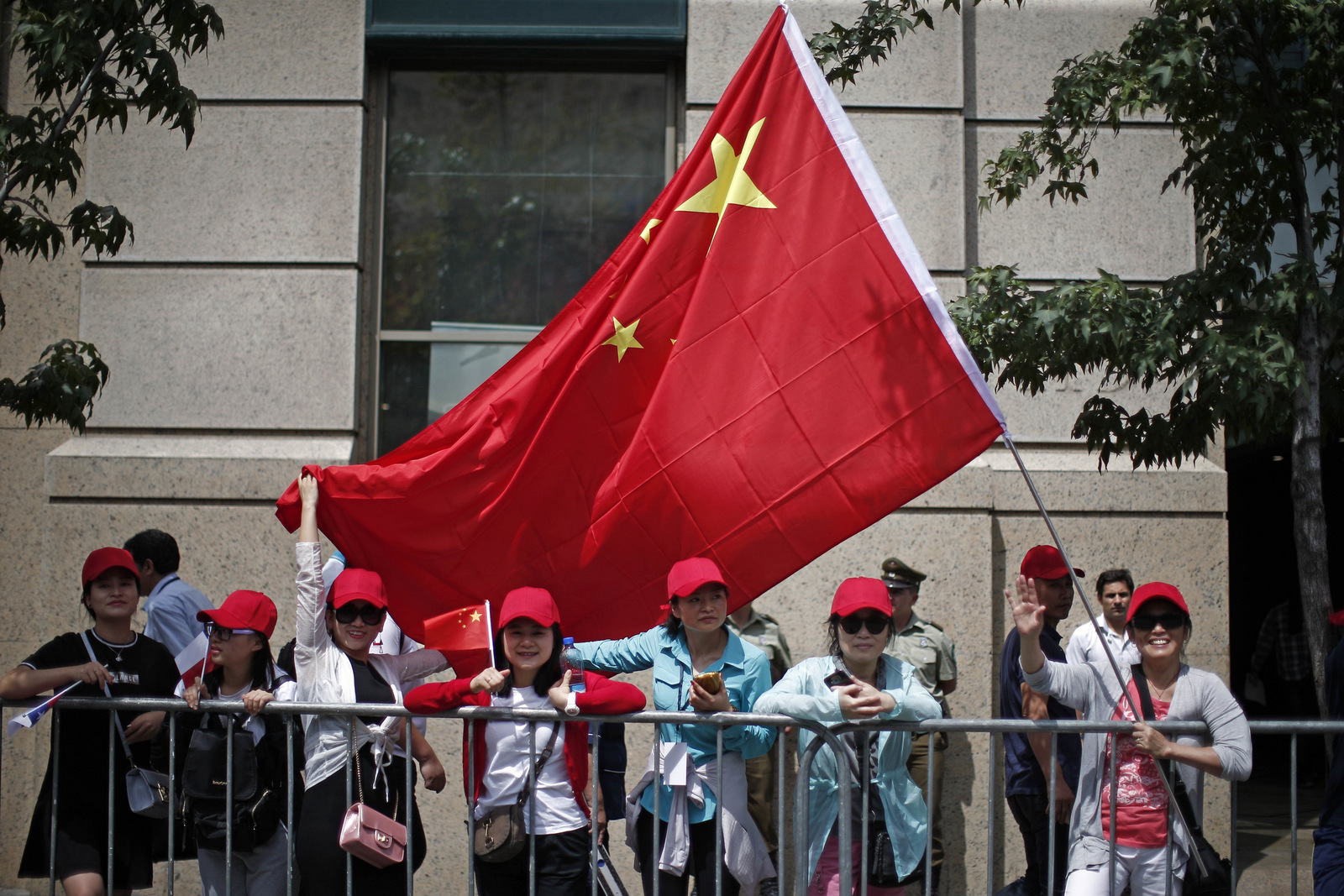 Members of the Chinese community living in Chile await the arrival of China's President Xi Jinping outside La Moneda presidential palace in Santiago, Chile, Tuesday, Nov. 22, 2016. Jinping is in Chile after attending the APEC summit in Peru. (AP Photo/Luis Hidalgo)