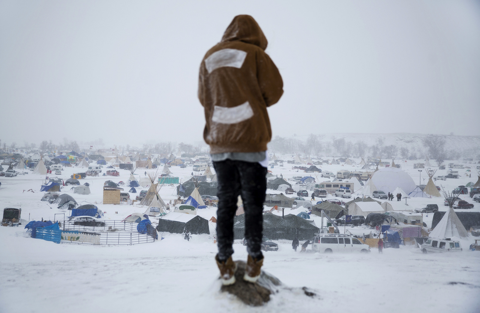 Damin Radford of New Zealand stands overlooking the Oceti Sakowin camp where people have gathered to protest the Dakota Access pipeline near Cannon Ball, N.D. Nov. 29, 2016. (AP Photo/David Goldman)