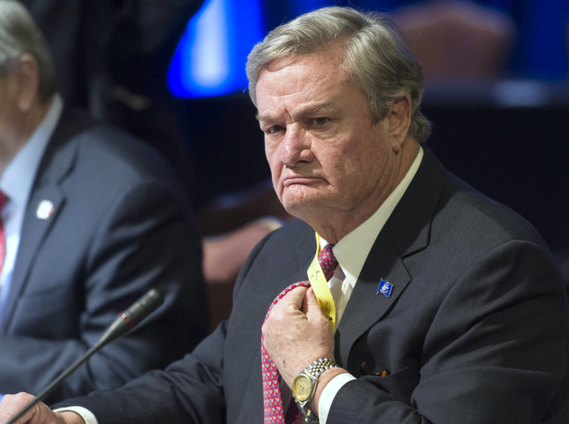 North Dakota Republican Gov. Jack Dalrymple adjusts his tie during a meeting in Washington. Feb. 21, 2015. (AP Photo/Cliff Owen, File)