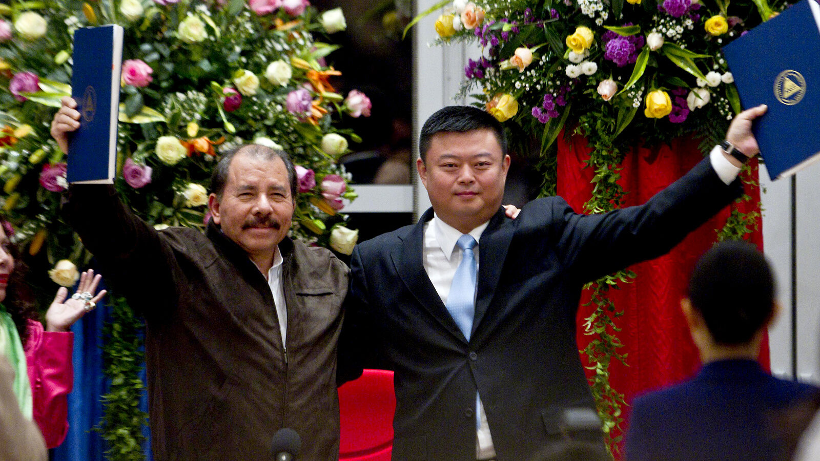 In this June 14, 2013 file photo, President Daniel Ortega, left, and Chinese businessman Wang Jing hold up a concession agreement for the construction of a multibillion-dollar canal at the Casa de los Pueblos in Managua. (AP Photo/Esteban Felix)