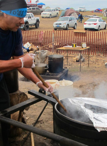 Phil Daw Sr., of Albuquerque, New Mexico, helps cook beef stew to feed hundreds at an encampment near North Dakota's Standing Rock Sioux reservation. (AP Photo/James MacPherson)