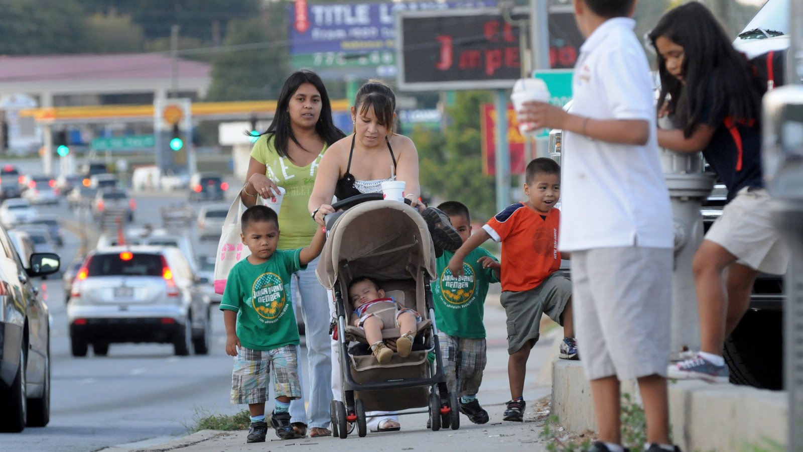 Undocumented immigrants from Mexico, walk with their children along Jimmy Carter Blvd. in Norcross, Ga. The two women walk great distances everyday as they would risk deportation if they drove a car without a driver’s license. (AP Photo/Erik S. Lesser)