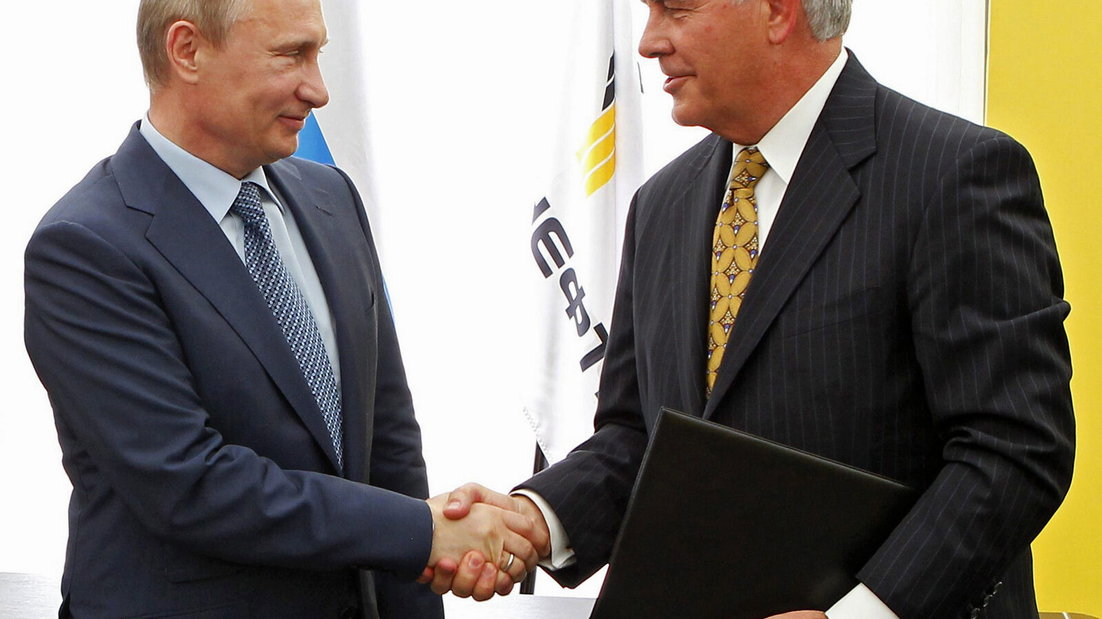 Russian President Vladimir Putin, left, and Exxon Mobil Corp. CEO Rex Tillerson shake hands at a signing ceremony of an agreement between state-controlled Russian oil company Rosneft and Exxon Mobil corporation at the Black Sea port of Tuapse, southern Russia, Friday, June 15, 2012. (AP Photo/RIA-Novosti, Mikhail Klimentyev, Presidential Press Service)