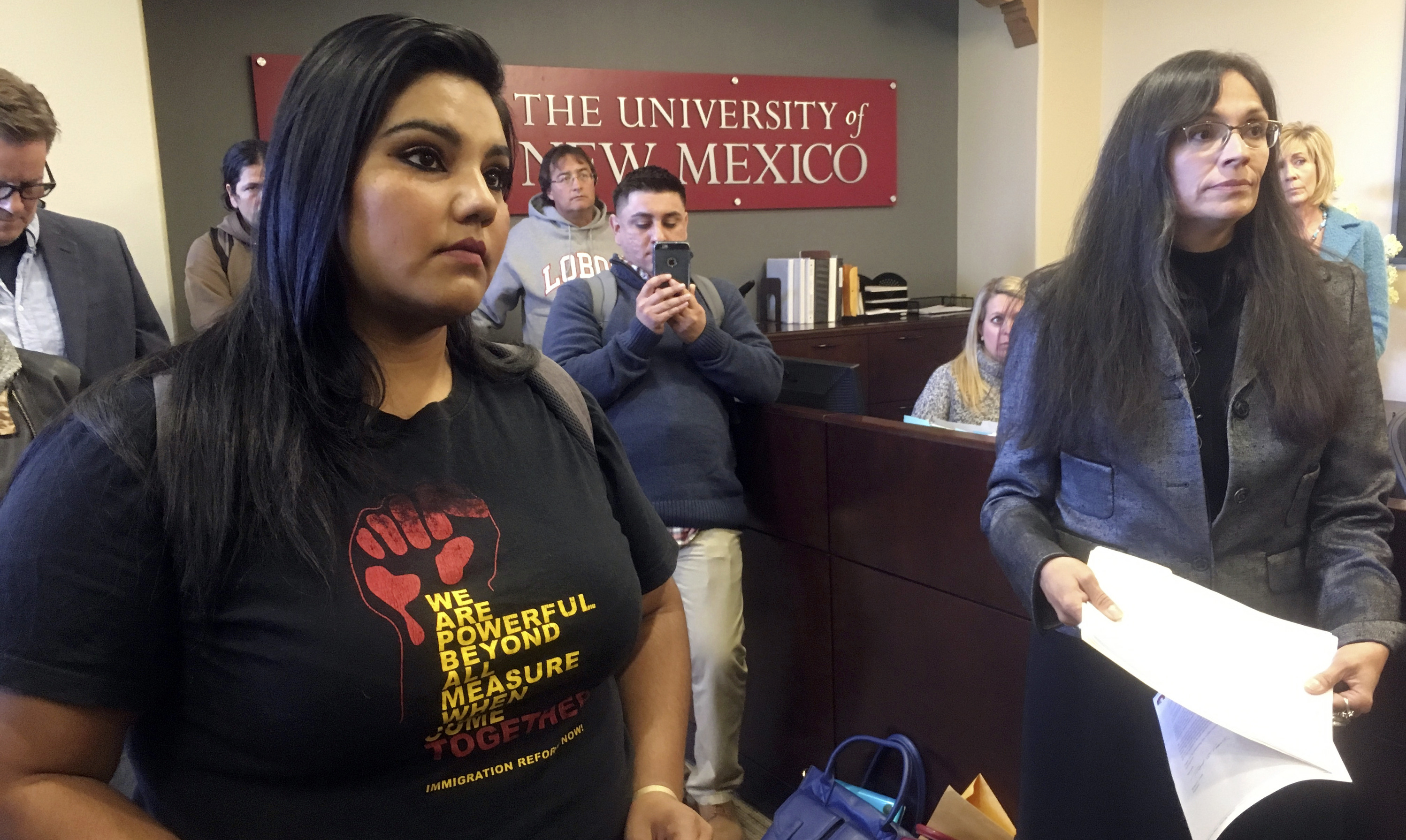 University of New Mexico student LuzHilda Campos, left, and Chicano studies professor Irene Vasquez, right, present a letter with hundreds of signatures on Friday, Nov. 18, 2016, to school president Bob Frank asking him to declare the campus a "sanctuary university," in Albuquerque, N.M.. (AP Photo/Russell Contreras)