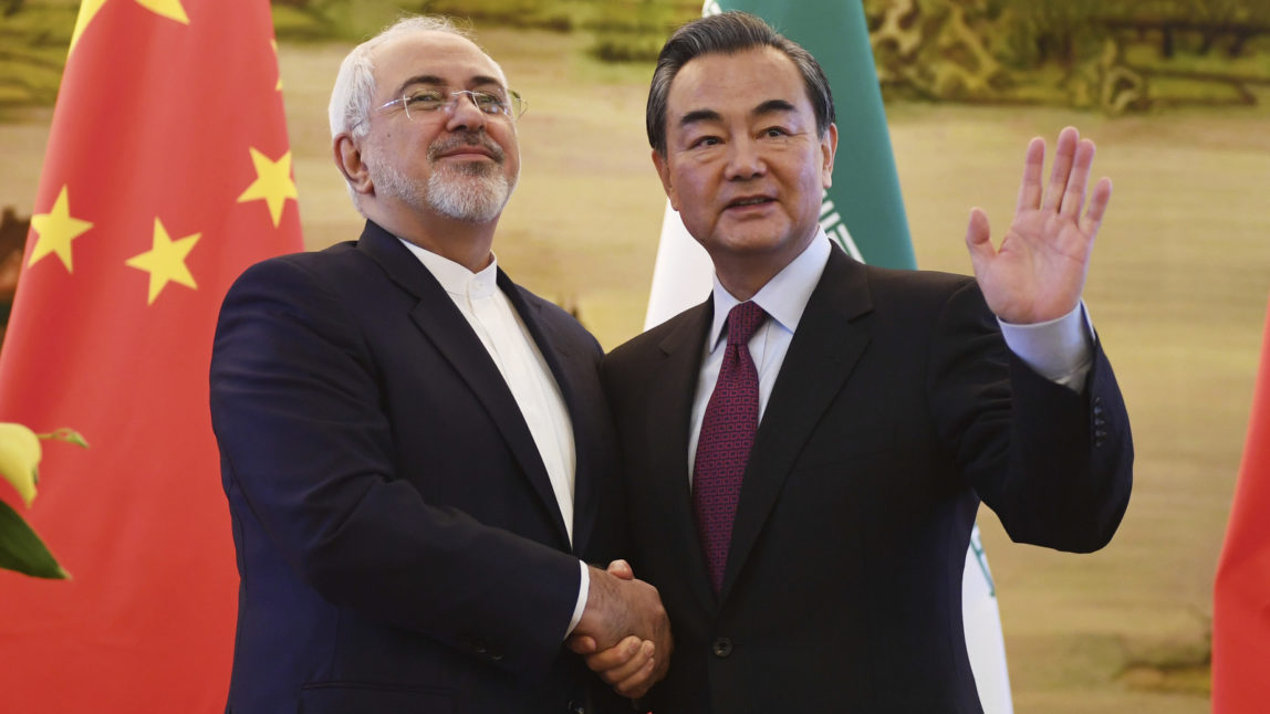 Iranian Foreign Minister Mohammad Javad Zarif, left, shakes hands with Chinese Foreign Minister Wang Yi after a joint press conference in Beijing Monday, Dec. 5, 2016. (Greg Baker/Pool Photo via AP)
