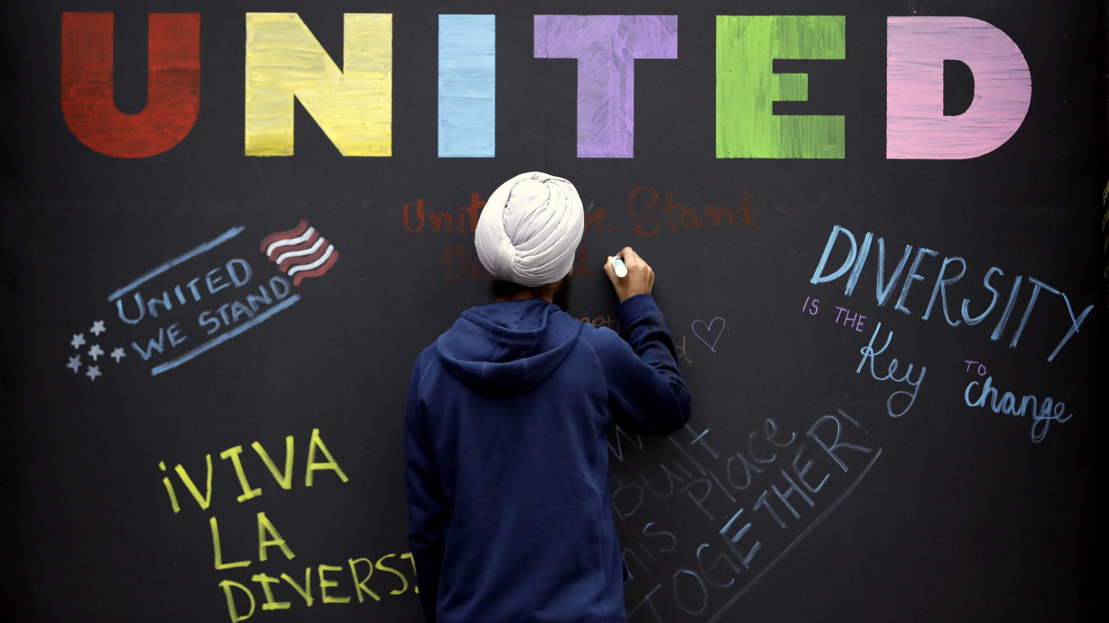 Texas A&M student Harsimran Singh, from India, signs a message board outside Kyle Field where an "Aggies United" event is scheduled for Tuesday evening at Texas A&M University Tuesday, Dec. 6, 2016, in College Station, Texas. The event is taking place at the same time Richard Spencer, who leads a movement that mixes racism, white nationalism and populism, is set to speak at a separate event at the university after being invited by a former student. (AP Photo/David J. Phillip)