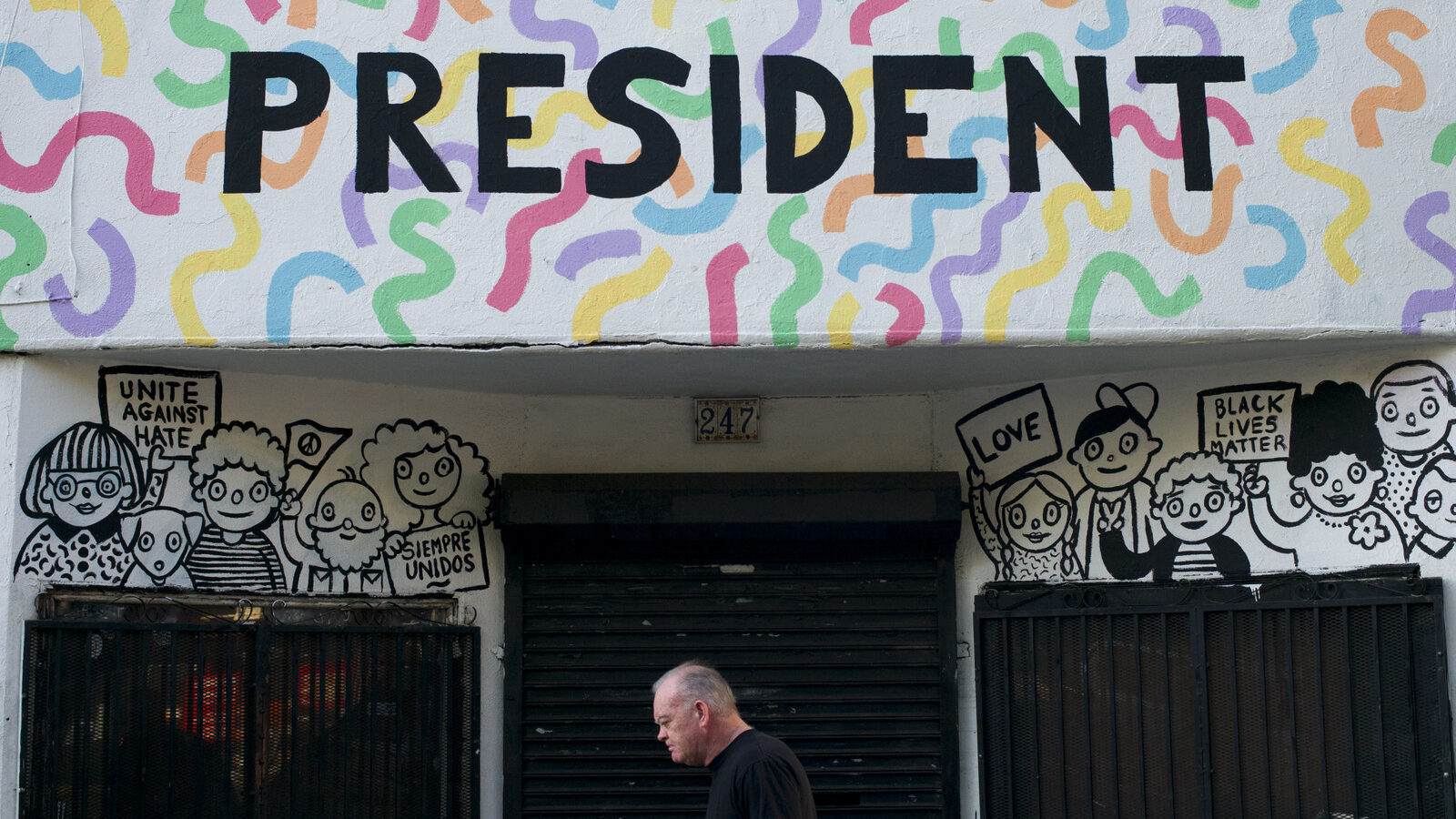 A man walks past a building with the phrase "Not Our President" written on the facade to protest against President-elect Donald Trump Thursday, Dec. 8, 2016, in Los Angeles. (AP Photo/Jae C. Hong)
