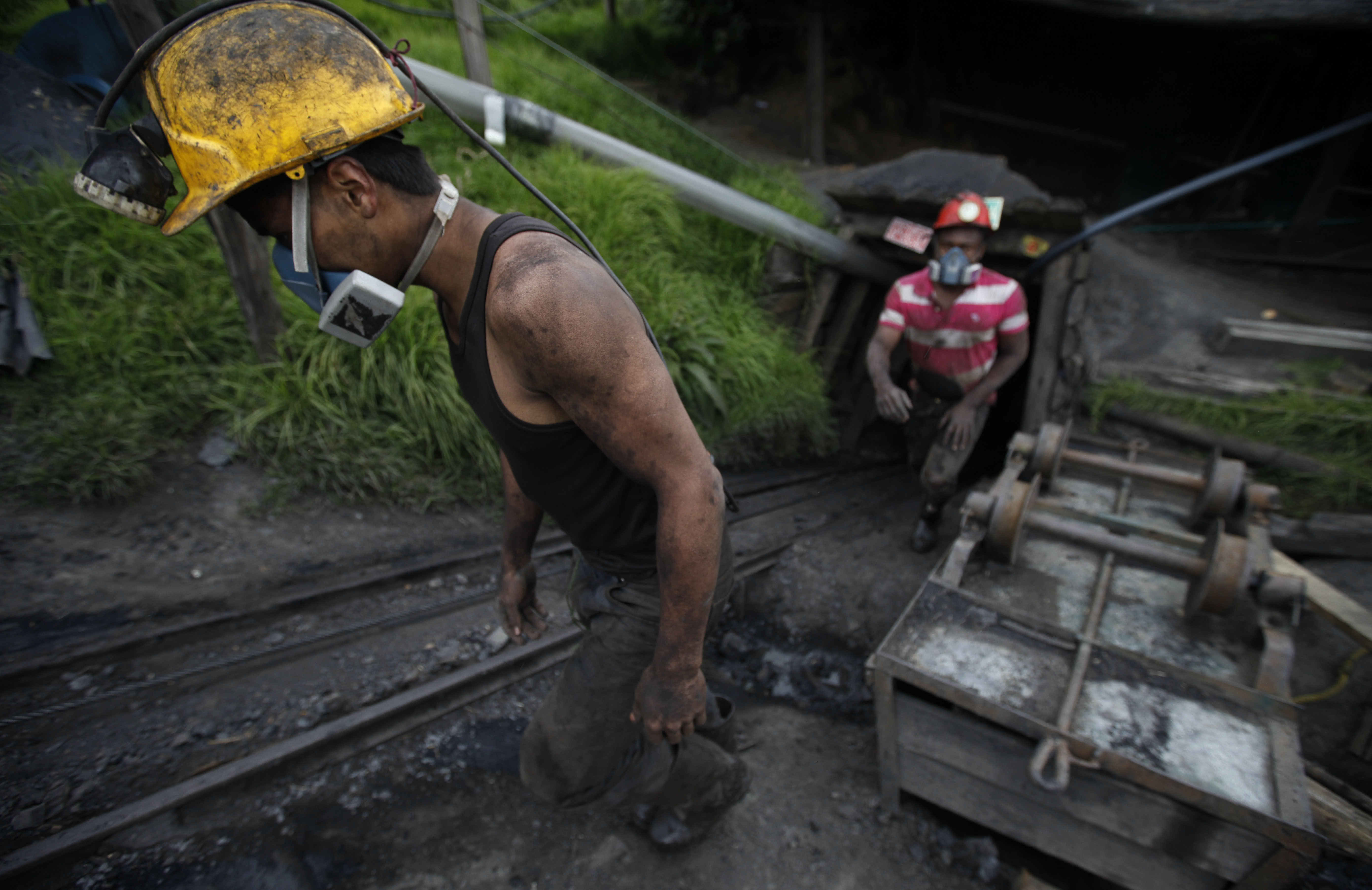 Miners leave the tunnel after their shift at La Flauta coal mine in Tausa, Colombia, Tuesday, Sept. 24, 2013. Tausa residents fear that La Flauta will be closed if authorities declare the area a nature reserve in which mining is prohibited. (AP Photo/Fernando Vergara)
