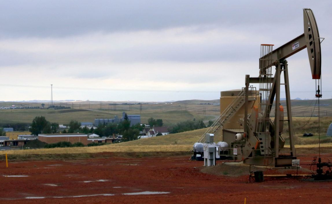 A derrick pumps oil on a hill above Alexander, in the Bakken region of N.D. AP Photo/Martha Irvine)