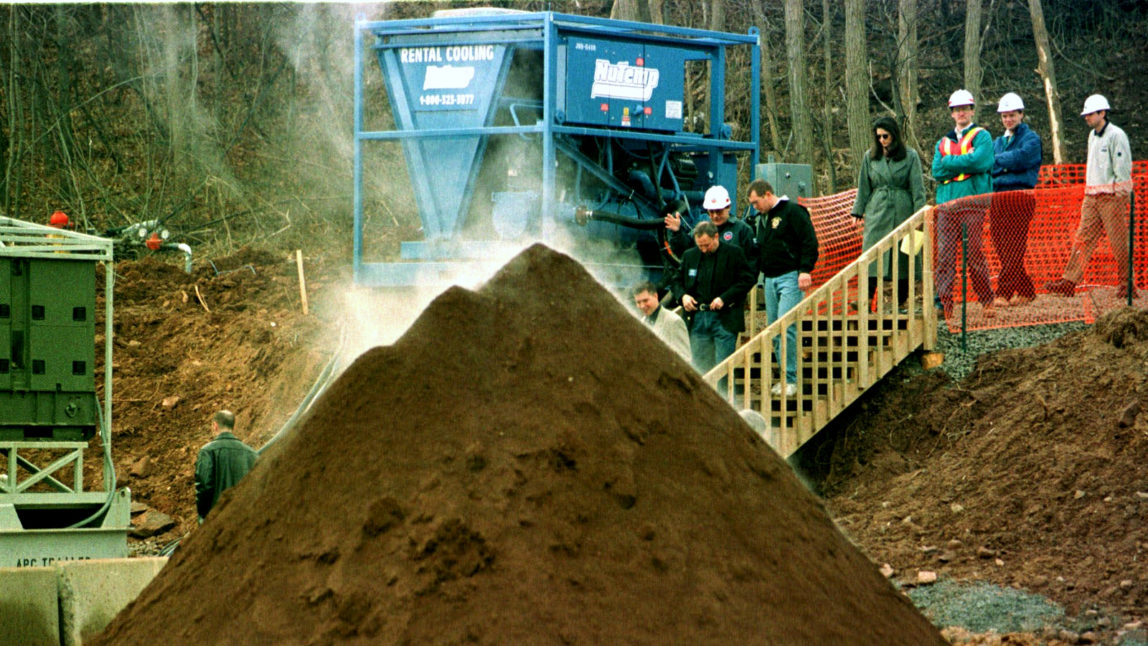 U.S. Environmental Protection Agency officials and visitors walk past a steaming mound of decontaminated soil during a tour of the Industrial Latex Superfund site in Wallington, N.J., Friday, Feb. 12, 1999. (AP Photo/Mike Derer)