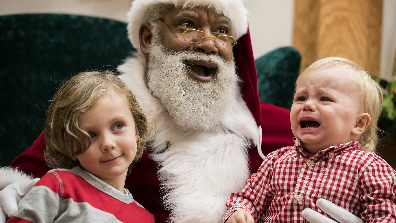 In this Thursday, Dec. 1, 2016 photo, Larry Jefferson, playing the role of Santa, smiles with Auden Good and his one-year-old brother Ezra of Ramsey while posing for photos at the Santa Experience at Mall of America in Bloomington, Minn. (Leila Navidi/Star Tribune via AP)