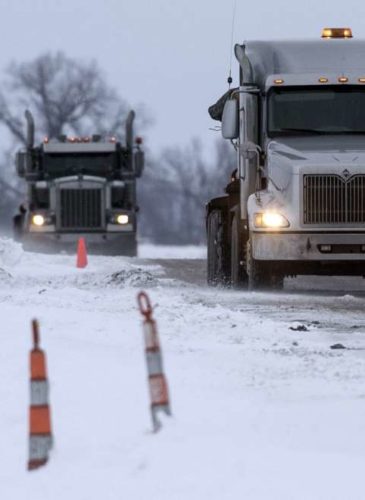 Trucks haul contaminated soil and snow away from the site of a diesel fuel spill Thursday, Jan. 26, 2017, after a pipeline owned by Magellan Midstream Partners broke near Hanlontown, Iowa, on Wednesday. (Chris Zoeller /AP)