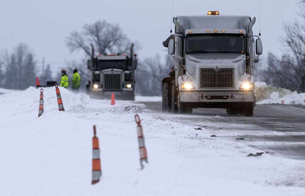 Trucks haul contaminated soil and snow away from the site of a diesel fuel spill Thursday, Jan. 26, 2017, after a pipeline owned by Magellan Midstream Partners broke near Hanlontown, Iowa, on Wednesday. (Chris Zoeller /AP)