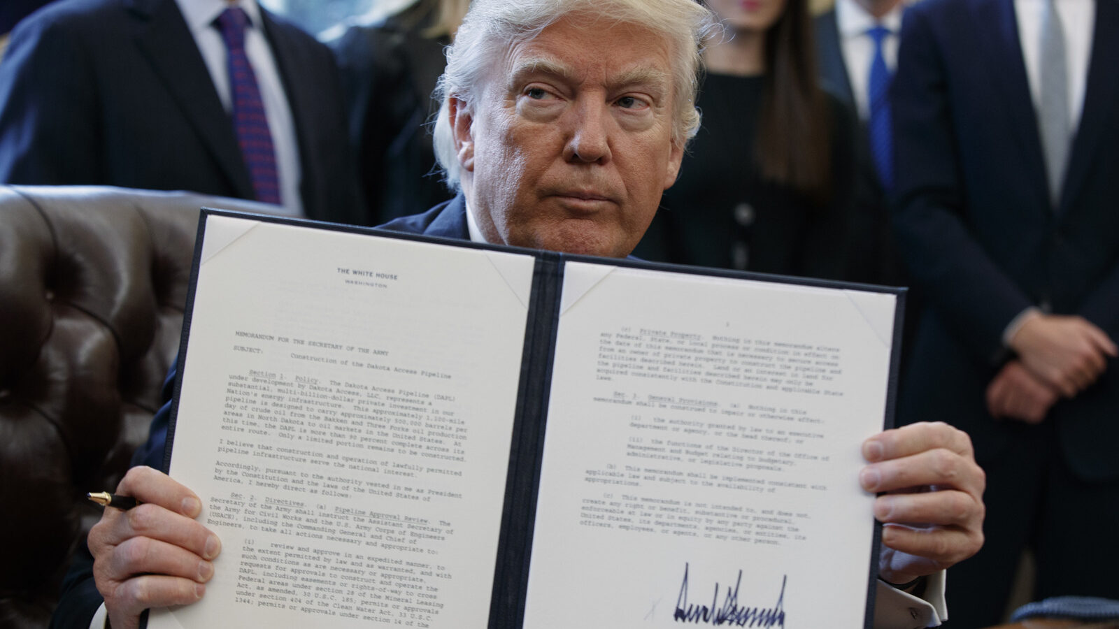 President Donald Trump shows off his signature on an executive order about the Dakota Access pipeline, Tuesday, Jan. 24, 2017, in the Oval Office of the White House in Washington. (AP/Evan Vucci)