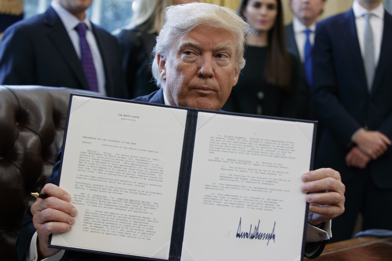President Donald Trump shows off his signature on an executive order about the Dakota Access pipeline, Tuesday, Jan. 24, 2017, in the Oval Office of the White House in Washington. (AP/Evan Vucci)