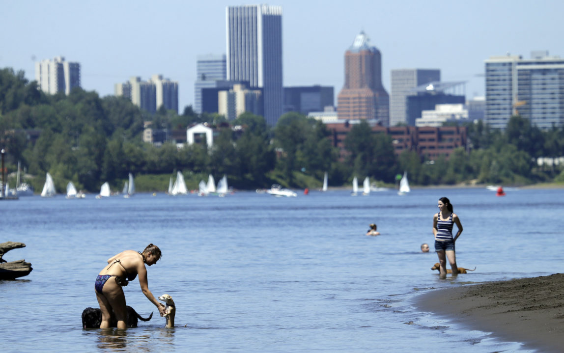 People, pets and sailors use the Willamette River to cool off in Portland, Ore., Monday, July 6, 2015. The city has spent more than $1 billion cleaning up PCB pollution in the river, which is alleged to have been dispersed by Monsanto. (AP/Don Ryan)