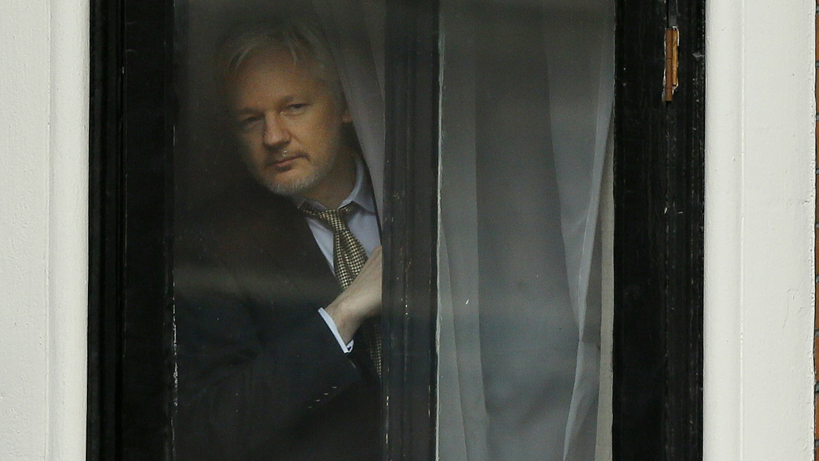 Wikileaks founder Julian Assange appears at the window before speaking on the balcony of the Ecuadorean Embassy in London, Friday, Feb. 5, 2016. (AP/Kirsty Wigglesworth)