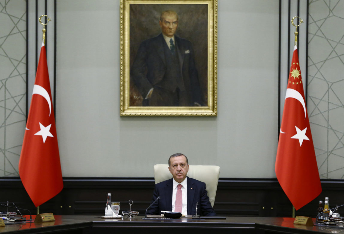 Under a portrait of Turkish Republic founder Mustafa Kemal Ataturk,Turkey's President Recep Tayyip Erdogan chairs the cabinet meeting, in Ankara, Turkey, Monday, July 25, 2016. (Presidential Press Service/AP)