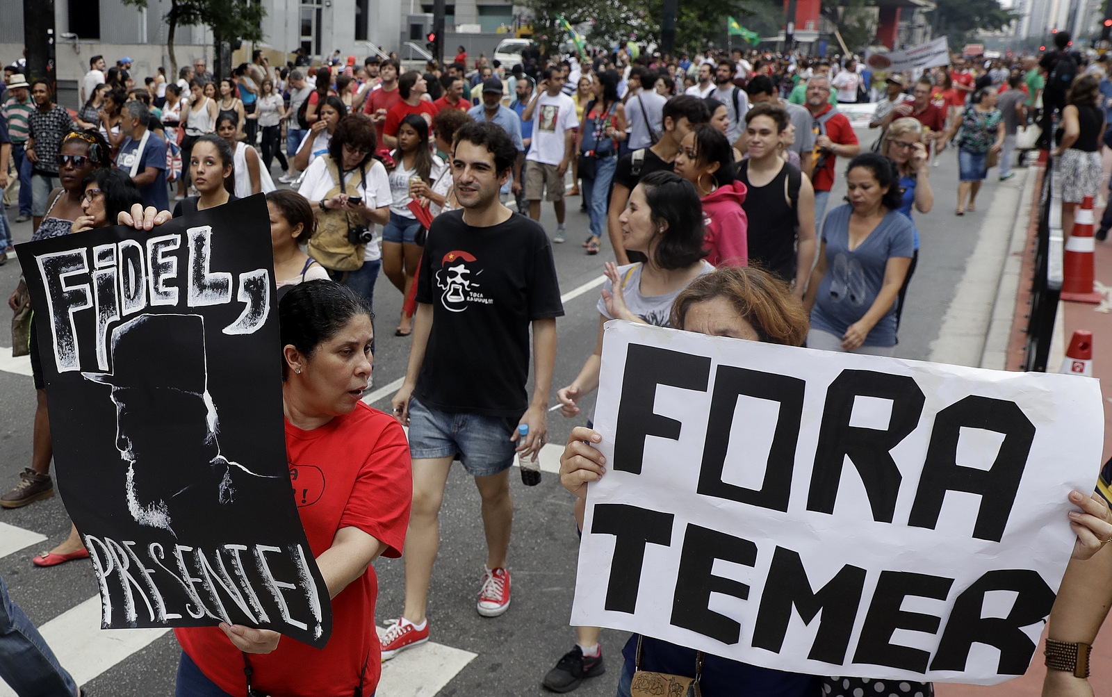 Demonstrators march with a sign that says in Portuguese "Get out Temer" and a drawing of Cuba's late President Fidel Castro, as they demand the impeachment of Brazil's President Michel Temer in Sao Paulo, Brazil, Nov. 27, 2016. (AP/Andre Penner)