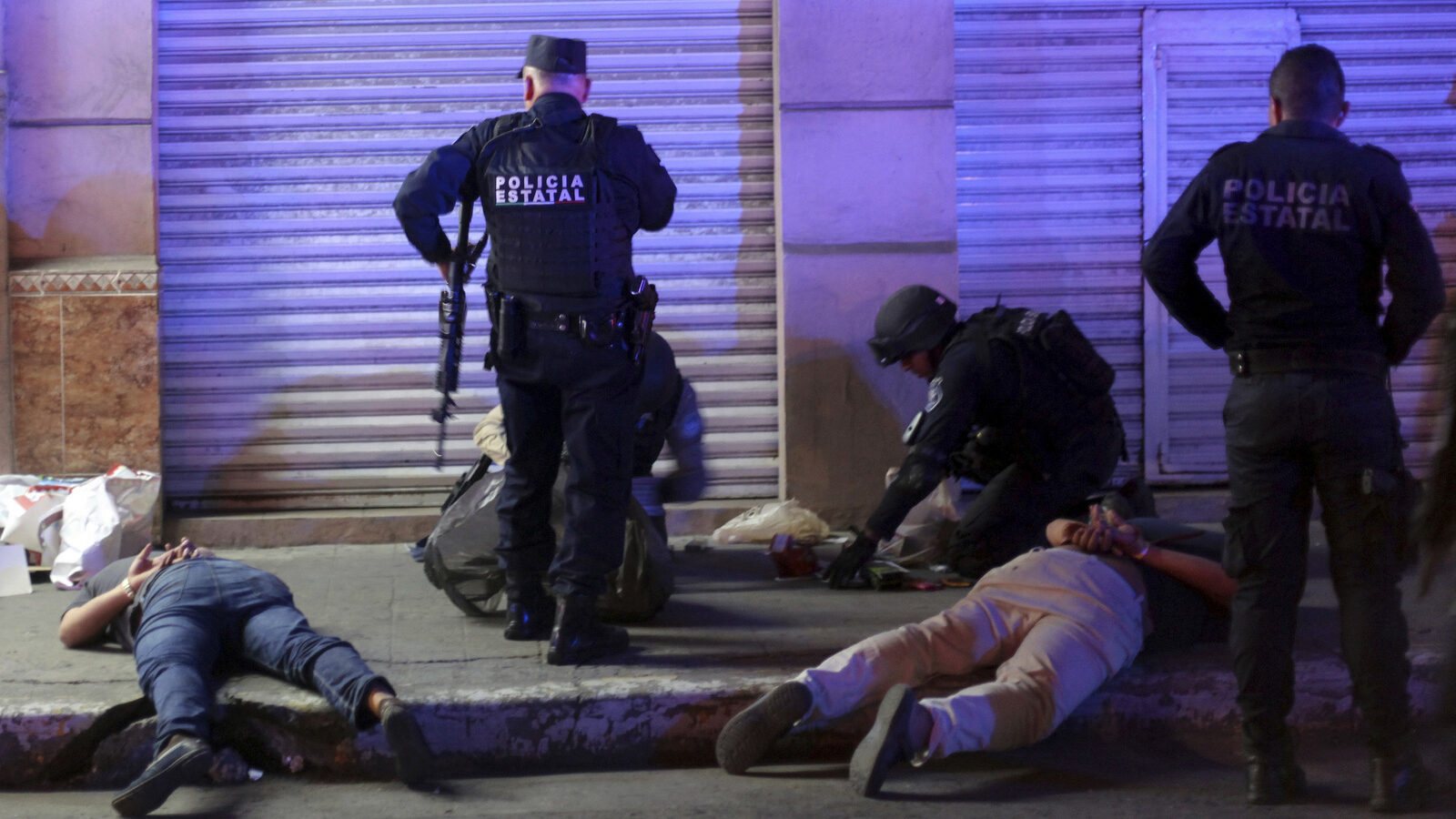 Suspects are detained by state police after they were caught looting in Veracruz, Mexico, early Thursday, Jan. 5, 2017. (AP/Felix Marquez)