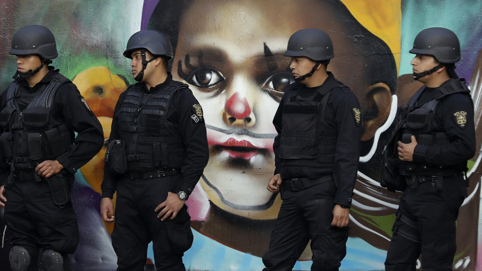 Police providing security walk in front of street art as thousands marched in anger against the government of Enrique Pena Nieto following a 20 percent rise in gas prices, in Mexico City, Monday, Jan. 9, 2017. Demonstrators have been protesting across Mexico since the gasoline price hike took effect on New Year's Day, and the anger has occasionally erupted into violence, including several days of looting last week. (AP/Rebecca Blackwell)