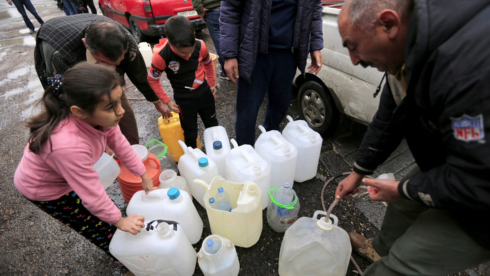 People fill plastic containers with water from a tap water in Damascus, Syria, Monday, Jan. 16, 2017. Water cut-offs have been almost continuous since Dec. 22, in the worst water crisis known to Damascus residents. (AP/Hassan Ammar)