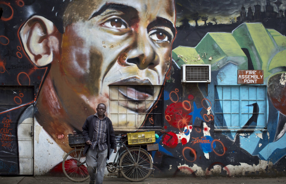 A man walks away after leaning his bicycle against a mural of President Barack Obama at the GoDown Arts Centre in Nairobi, Kenya ahead of the visit of Obama. (AP/Ben Curtis)