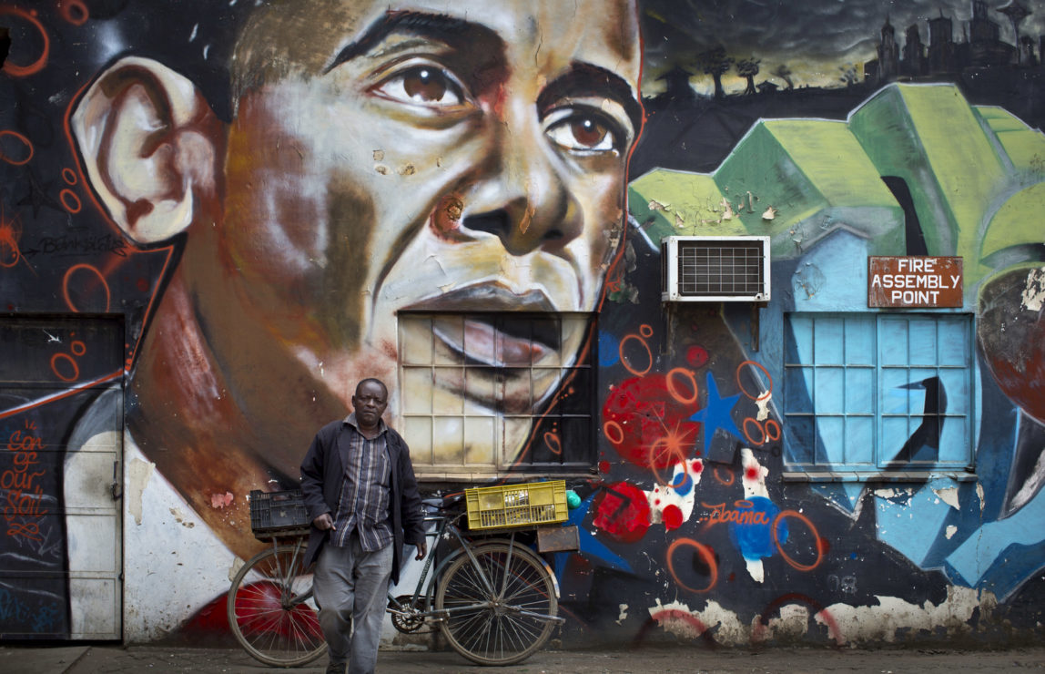 A man walks away after leaning his bicycle against a mural of President Barack Obama at the GoDown Arts Centre in Nairobi, Kenya ahead of the visit of Obama. (AP/Ben Curtis)