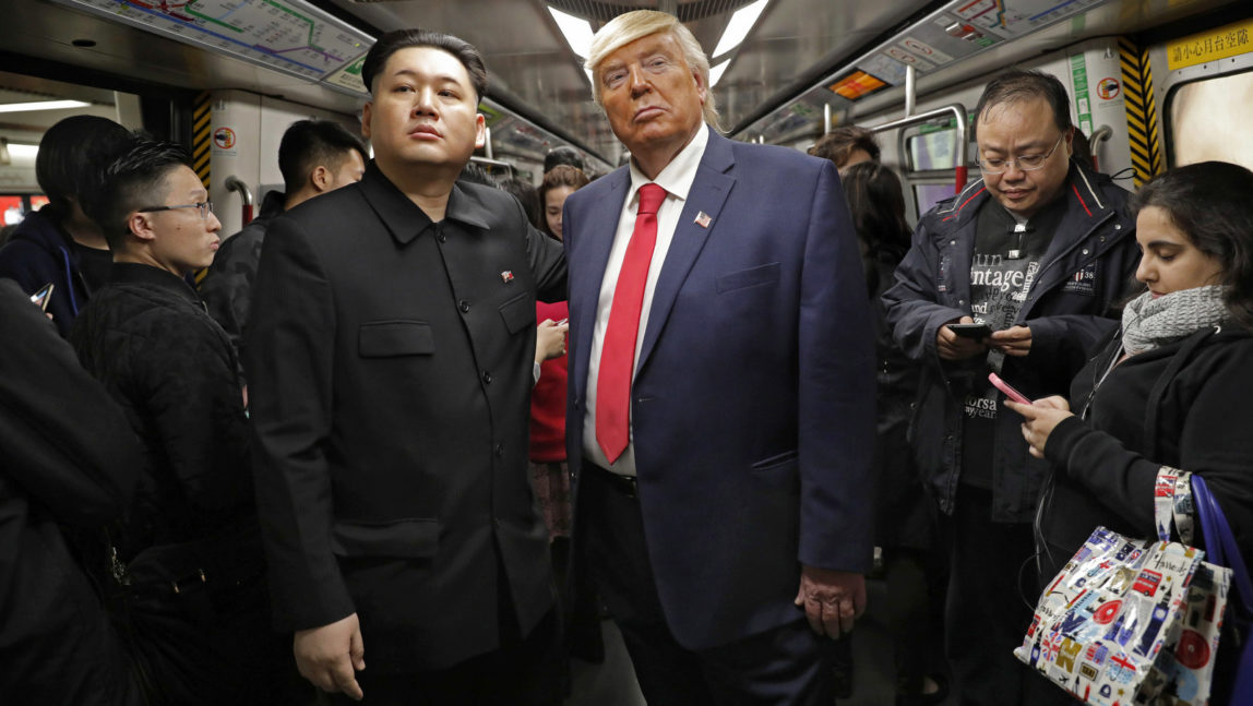 Kim Jong Un and Donald Trump impersonators, Howard, left, and Dennis, right, (who only give their first name) stand side by side on a train to promote a music video they created in Hong Kong, Wednesday, Jan. 25, 2017. (AP Photo/Vincent Yu)