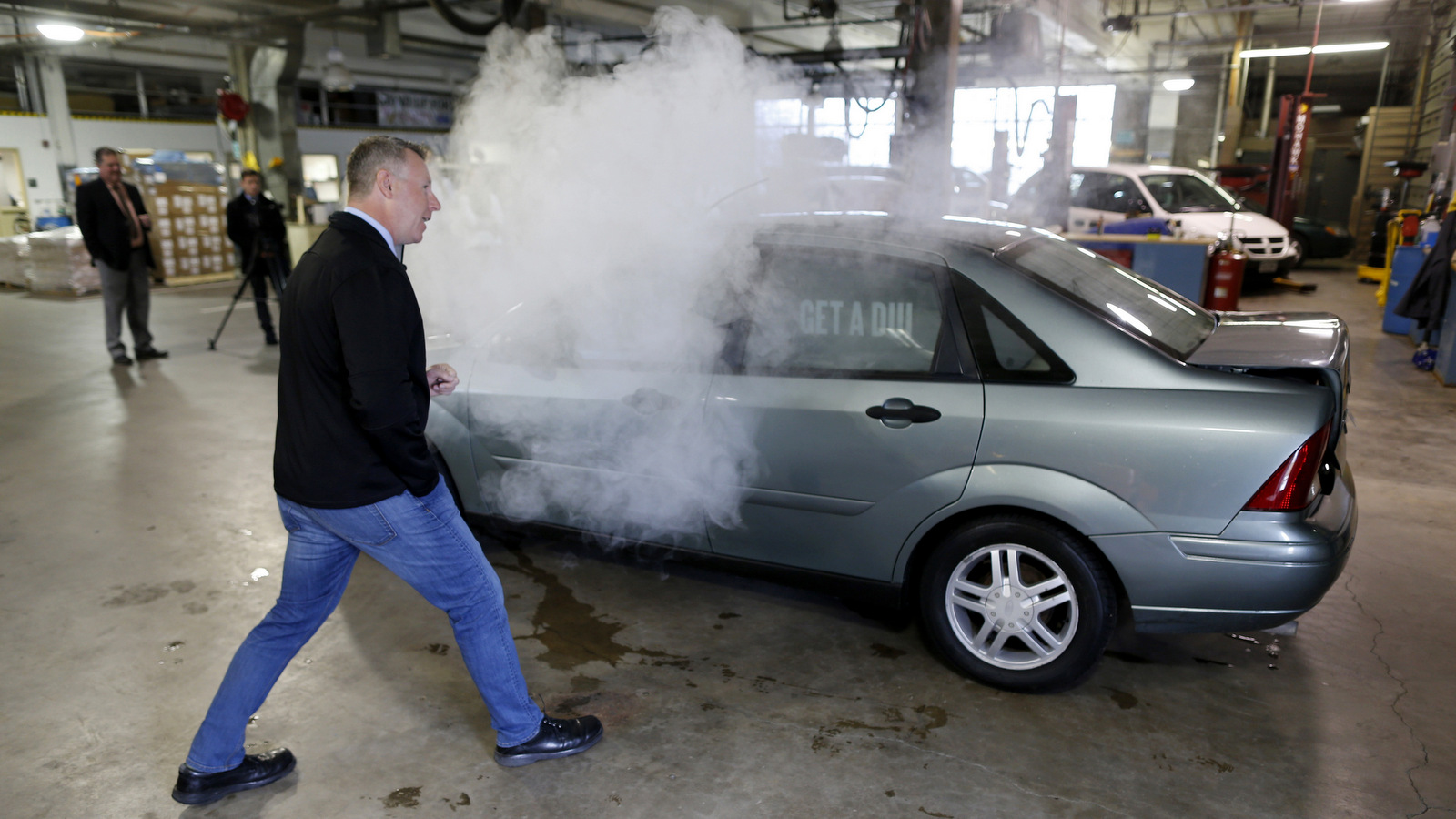 Smoke billows out of the windows of a car used in a campaign by the Colorado Department of Transportation to fight stoned driving during a demonstration in southeast Denver. (AP/David Zalubowski)