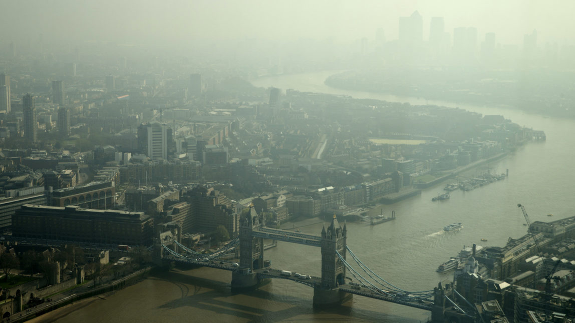 Tower Bridge and Canary Wharf, are just visible through the haze and smog in London, Friday, April 10, 2015. (AP/Alastair Grant)