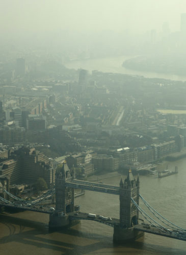 Tower Bridge and Canary Wharf, are just visible through the haze and smog in London, Friday, April 10, 2015. (AP/Alastair Grant)