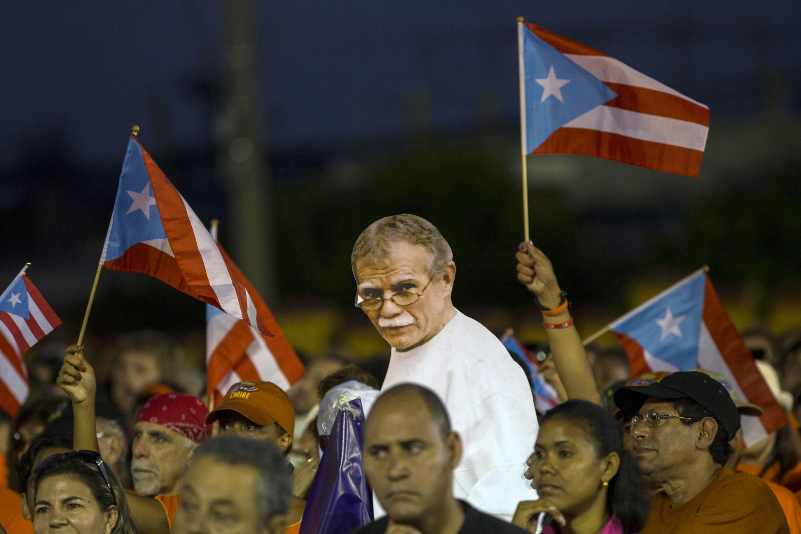 Puerto Rico's activists show a picture of independence fighter Oscar López Rivera, center, jailed in the United States, during an event celebrating Revolution Day in Santiago, Cuba, Sunday, July 26, 2015. Cuba marks the 62st anniversary of the July 26, 1953 rebel attack led by Fidel and Raul Castro on the Moncada military barracks. The attack is considered the beginning of Fidel Castro's revolution that culminated with dictator Fulgencio Batista's ouster. (AP Photo/Ramon Espinosa)