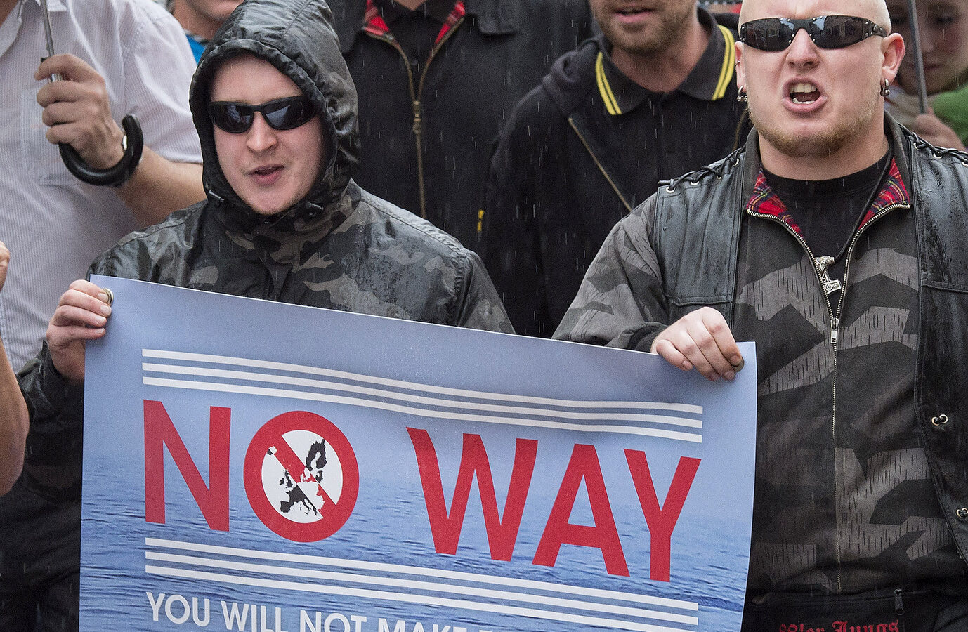 People take part at a demonstration initiated by right-wing NPD (National Democratic Party of Germany) against the German asylum law and asylum seekers in Riesa, eastern Germany, Tuesday, Aug. 18, 2015. (AP/Jens Meyer)